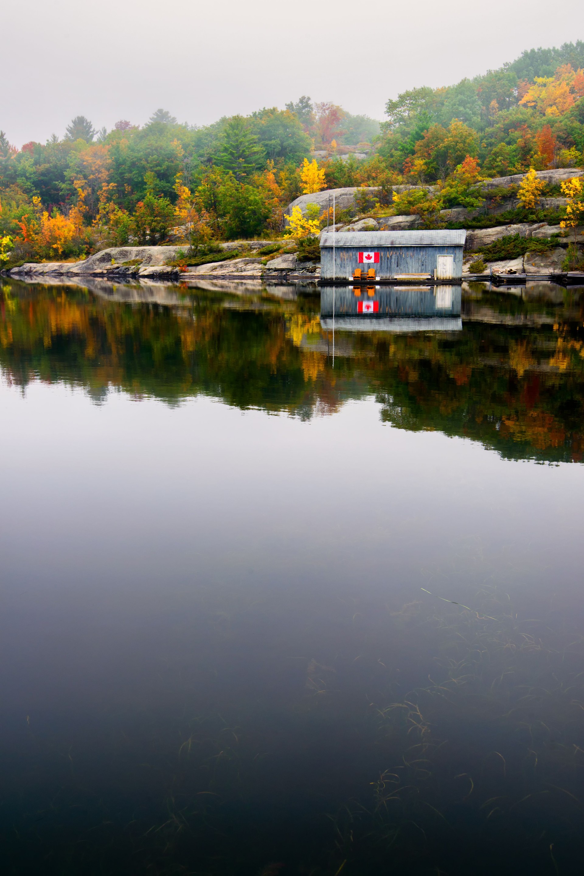 Wooden Boat House on a Calm Lake in the Fall